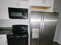 20230424 141326  Build-in microwave, electric glass top range and side-by-side refrigerator.